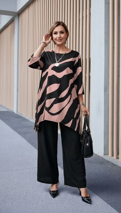 Strahle Selbstbewusstsein aus mit deinem lässigen, gemusterten Oberteil, schwarzen Hosen und der stylischen schwarzen Handtasche.