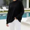 Entdecke deinen neuen Look: Im Pure Ease Pullover und weißen Hosen strahlst du am modernen Pool mit stilvollen Lounge Chairs.