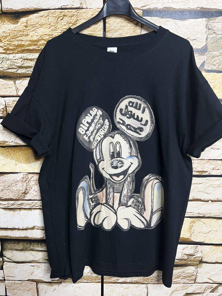 Vintage Cartoon Shirt: Schwarzes T-Shirt mit Mouse-Motiv und arabischer Schrift. Einzigartiges Cartoon-Design.