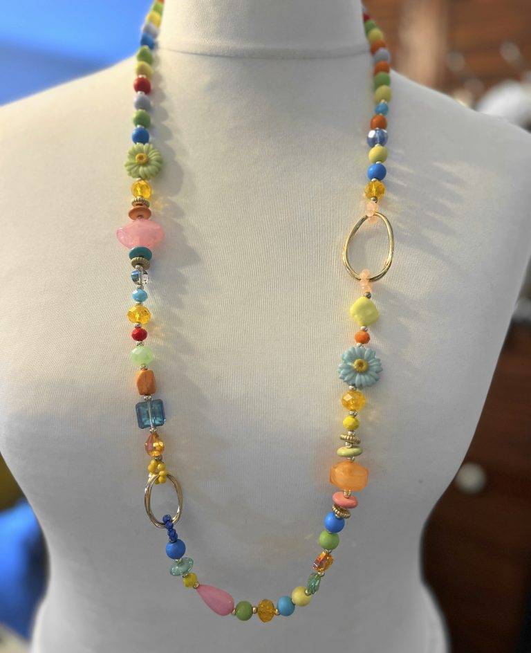 Bunte Happy Garden Kette mit Blumen und Perlen auf einer Schneiderpuppe. Modeschmuck Halskette.