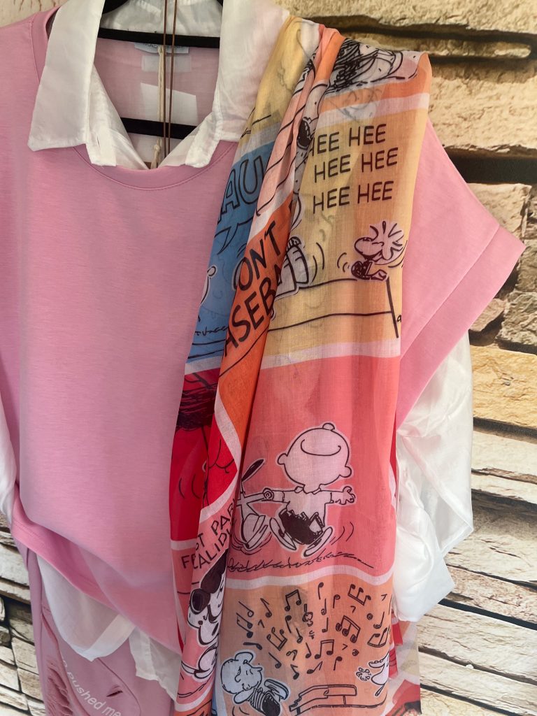 Shoppen Sie dieses rosa T-Shirt mit weißem Kragenhemd, gepaart mit dem Comic Mood Schal-Fun-Cartoon-Print, großartig für einen außergewöhnlichen Stil.