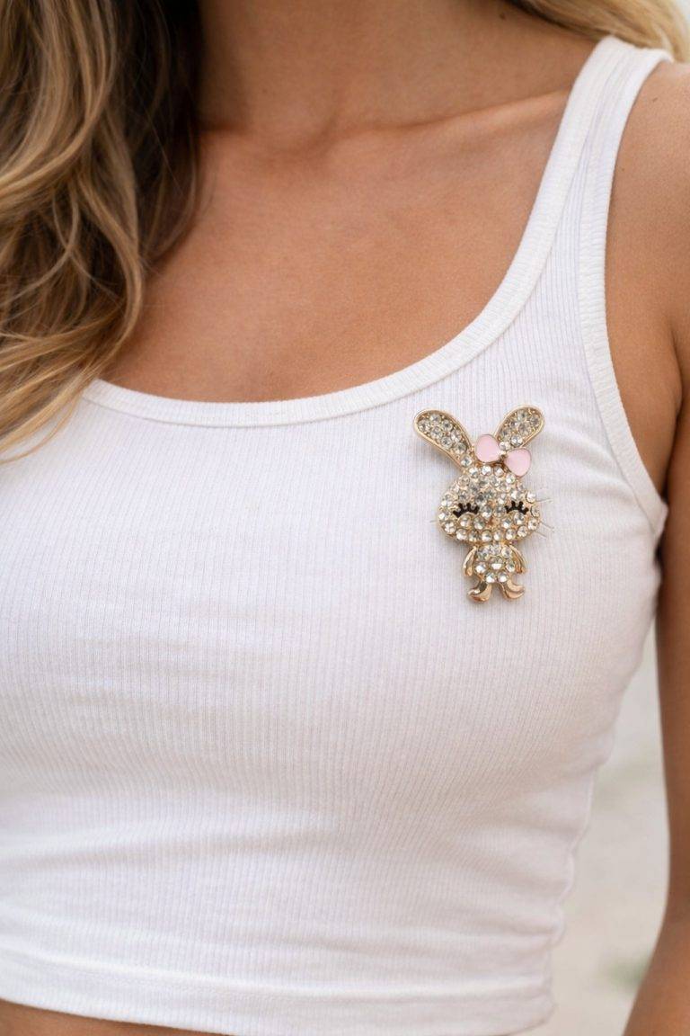 Kristall-Häschen Magnetbrosche auf weißem Top. Süße Hasenbrosche mit rosa Schleife. Modeschmuck.