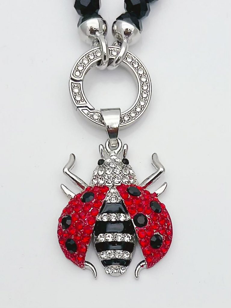 UHU Wechsel Anhänger: Ladybug pendant with red wings, black spots, striped body, and silver accents. Sparkling, stylish accessory.