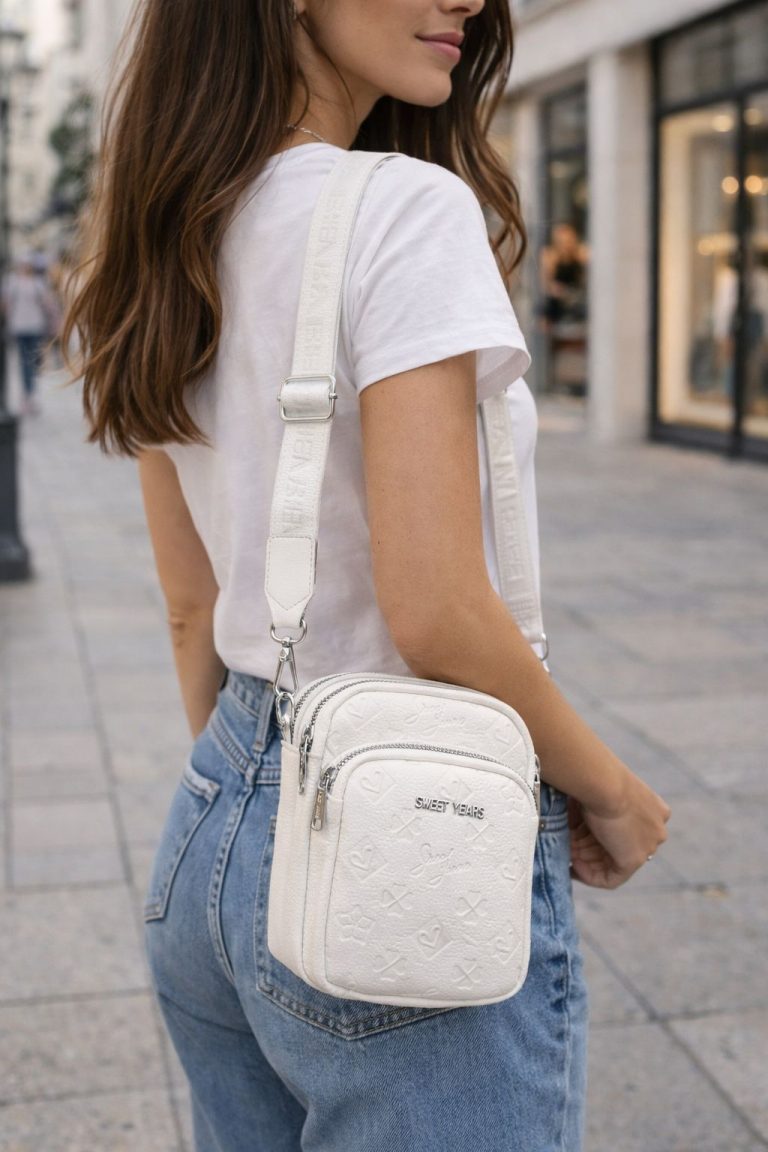Eine Frau im Freien mit der Sweet Years Handytasche, die ein geprägtes Design, Metalldetails und eine gebrandete Vorderseite aufweist - eine stilvolle und funktionale Wahl.