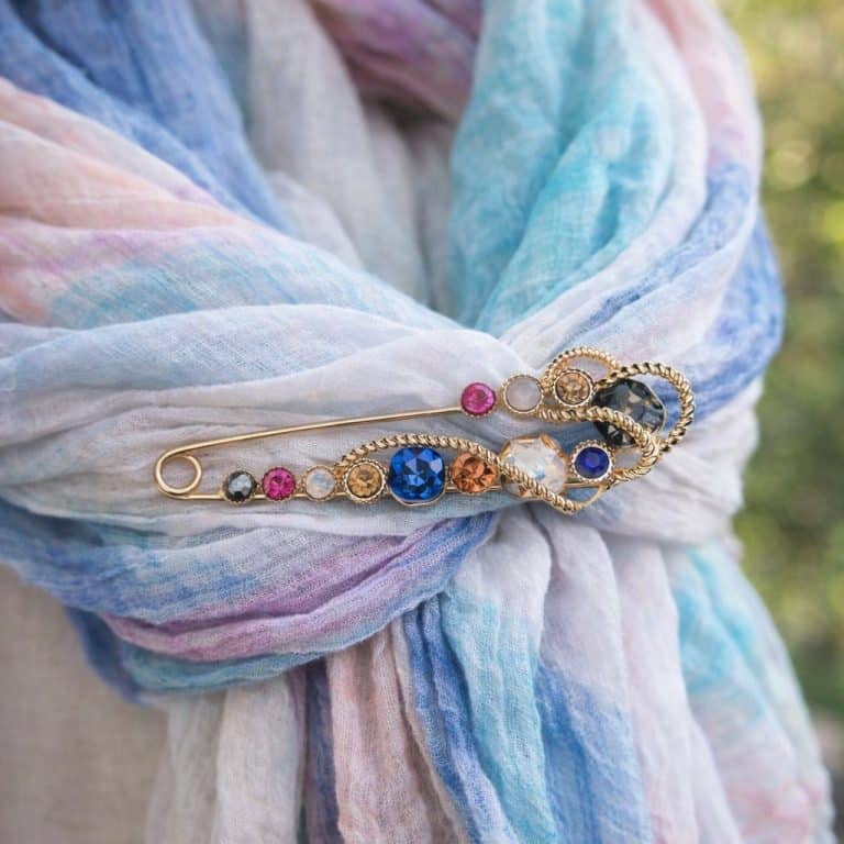 Pastellblauer, rosa und weißer Schal mit goldener Sicherheitsnadel von Jewel Dreams Nadel - farbenfrohe Edelsteine, sicherer Halt, elegantes Accessoire.