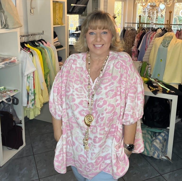 Frau in lockerem Bella Leo Tunika mit rosa und weißem Druck; bequem, stilvoll, perfekt für lässig schicke Garderobe auffrischen.