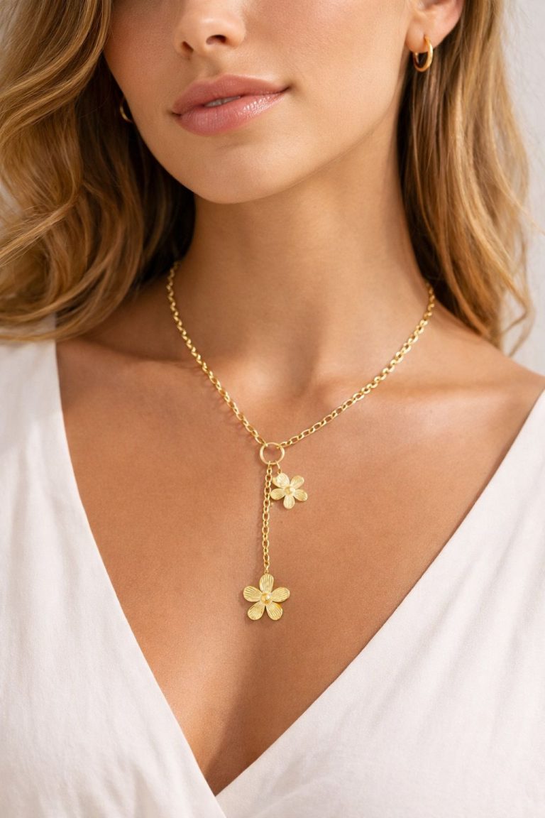 Frau trägt Golden Bloom Necklace; goldene Lariat-Kette mit zwei Blumenanhängern - perfekt für Eleganz und vielseitigen Stil.