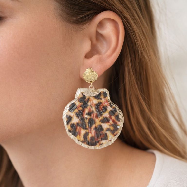 Nahaufnahme eines goldenen und schildpattfarbenen Muschelohrrings - ein mutiges, leichtes Accessoire, das den Alltagsstil perfekt aufwertet.