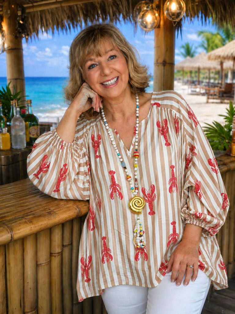 Frau in beige und rot gestreiften Coastal Lobster Tunika Bluse mit Hummerdrucken, perfekt für Strandtage; leicht & stylisch.