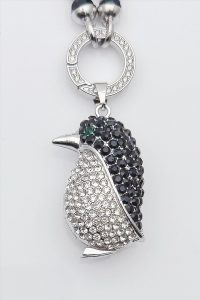 Stilvoller Anhänger in Pinguin-Form mit Strasssteinen an einem silbernen Ring, ideal zum Kombinieren mit anderen Halsketten und passend zum „Pfoten“-Anhänger. Tolle Geschenkidee.
