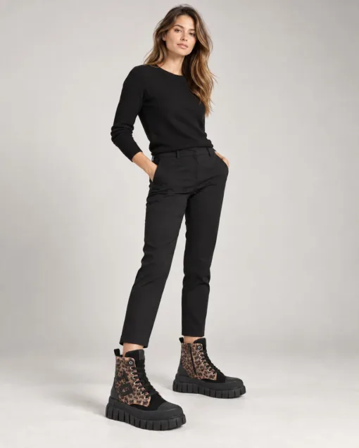 Frau in schwarzem Outfit mit Stiefeln